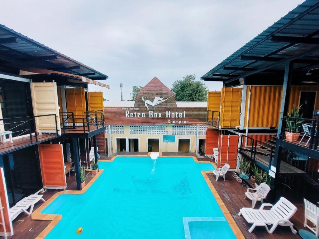 春蓬春蓬复古盒酒店的一个带椅子的大型游泳池和一间酒店