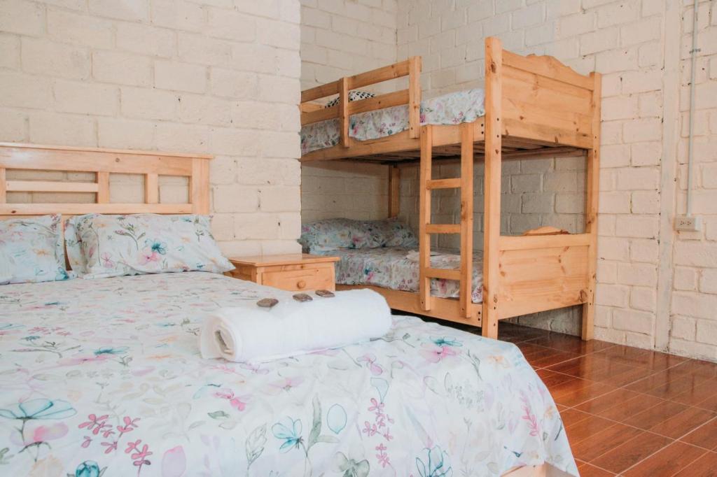 NaranjalHacienda CacaoyMango的一间卧室配有一张床和两张双层床。