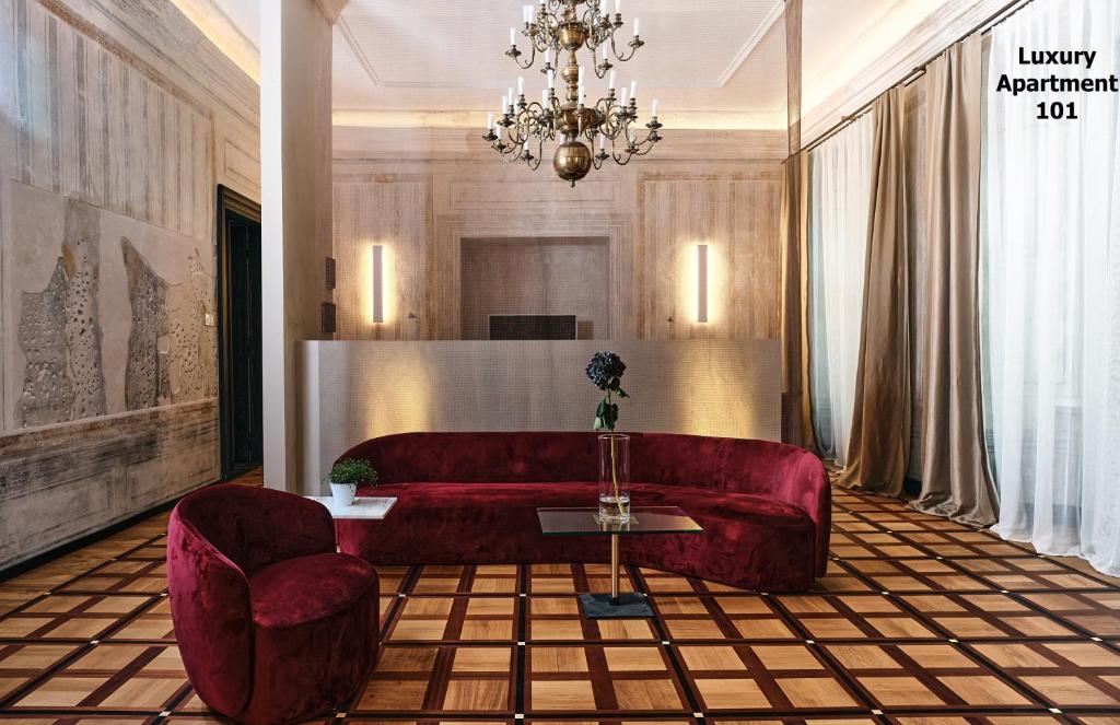 克拉科夫罗萨博得酒店的客厅配有红色的沙发和两把椅子