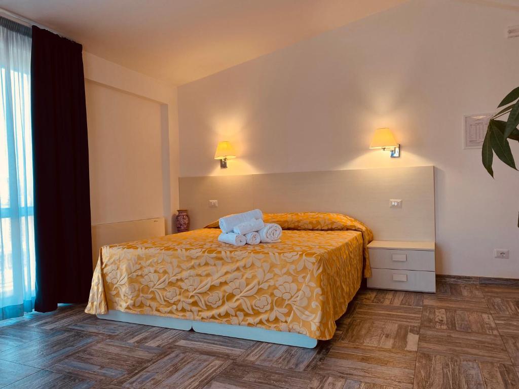 圣特雷莎加卢拉Hotel Muita di Mari的一间卧室配有一张床,上面有两条毛巾
