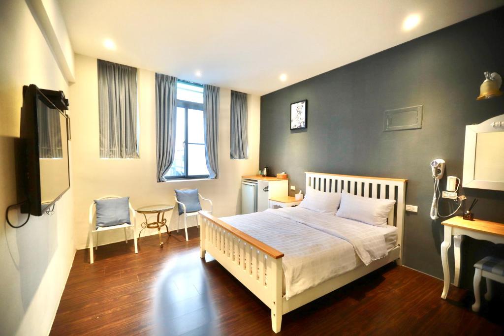 恒春古城好窩旅店的卧室配有一张床和一张桌子及椅子