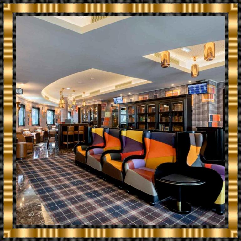 波尔图Hotel Jaguar Oporto - Airport to Hotel and City is a free Shuttle Service的一间图书馆,里面摆放着长沙发和椅子