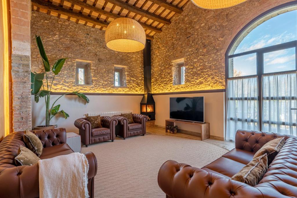 蓬特德莫林斯Masos Can Sot的客厅配有真皮沙发和平面电视