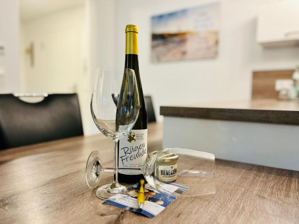 宾茨Ferienwohnung Meeresblick Haus Granitz in Prora的一张桌子上坐着一瓶葡萄酒和一杯