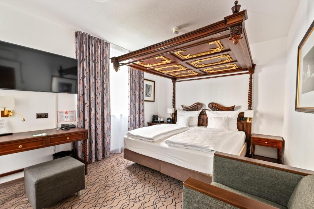慕尼黑市中心国王高级酒店的酒店客房设有一张大床和一张书桌。