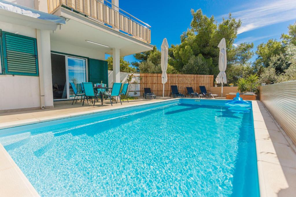 米欧纳Nono Jure , private pool & sauna的一个带椅子的游泳池以及一座房子