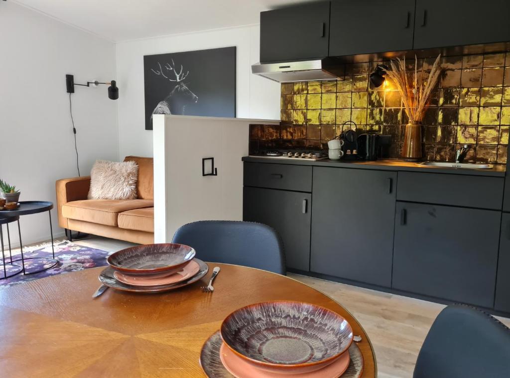 宁斯佩特Luxe Tiny House op de Veluwe的厨房配有木桌和盘子