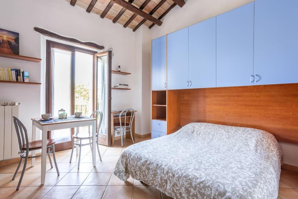 基亚拉瓦莱Monolocale la casa dei sogni的一间卧室配有一张床、一张桌子和一张桌子
