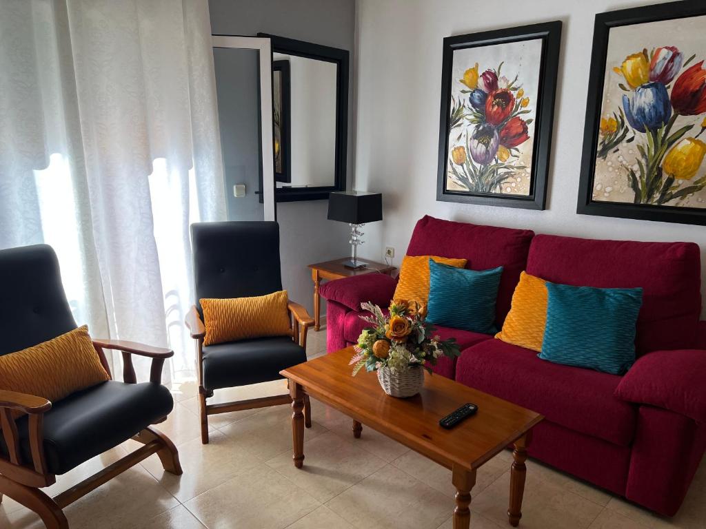 阿尔切纳旅游胡安妮塔奥皮公寓的客厅配有红色的沙发和两把椅子