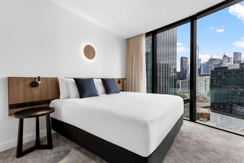 墨尔本Adina Apartment Hotel Melbourne Southbank的卧室设有白色的床和大窗户