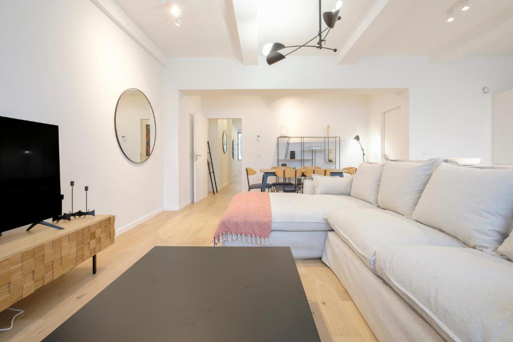 布鲁塞尔Appartement design 3 chambres proximité Grand-Place Bruxelles的客厅配有白色沙发和电视