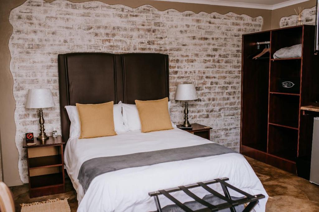 威特班克La Bendicion的一间卧室设有一张大床和砖墙
