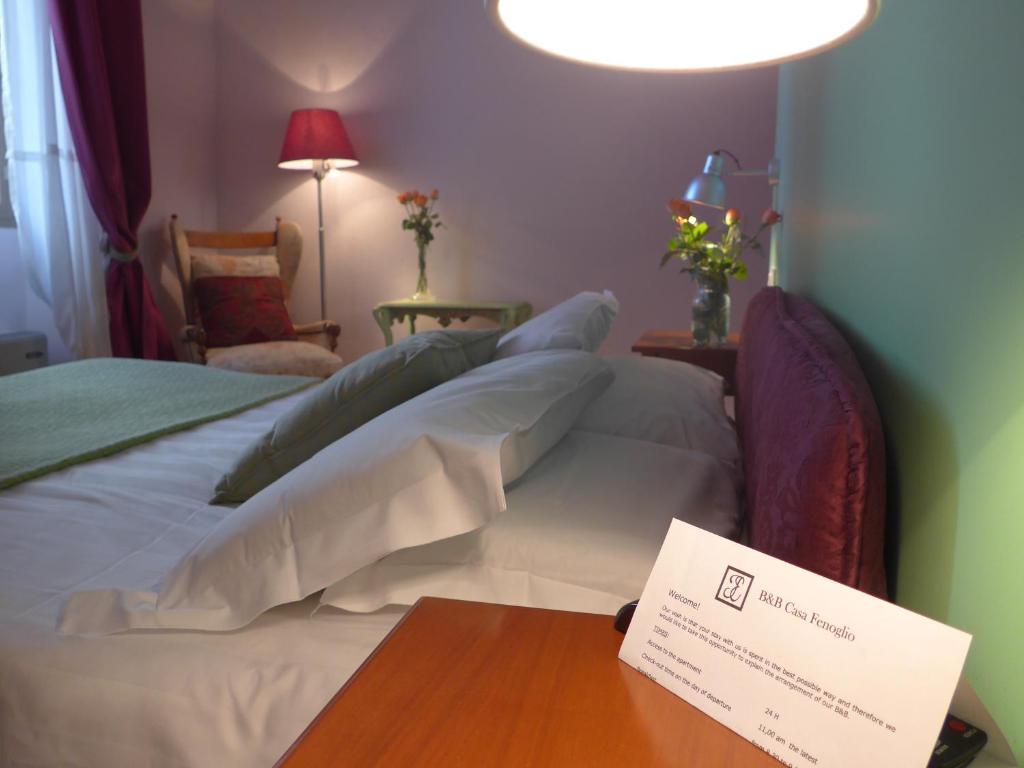 文蒂米利亚菲诺利奥住宿加早餐旅馆的一间酒店客房,配有一张桌子上标牌的床