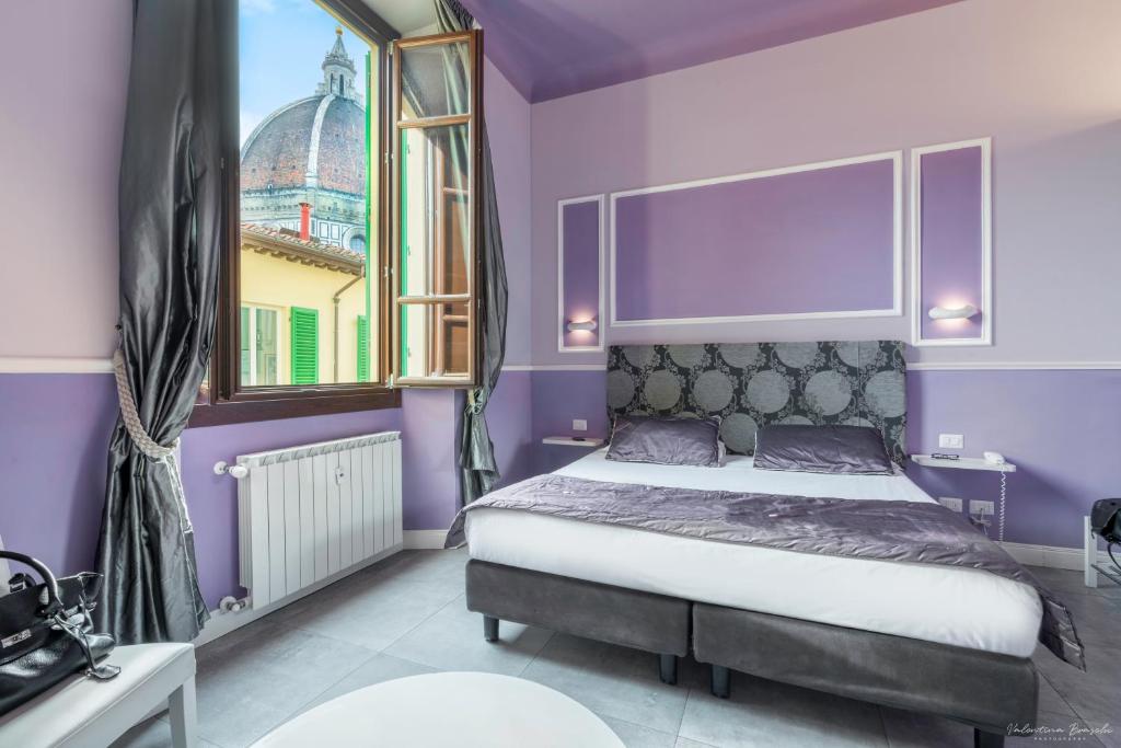 佛罗伦萨勒司坦泽教堂广场住宿加早餐酒店的一间卧室配有一张紫色墙壁和窗户的床