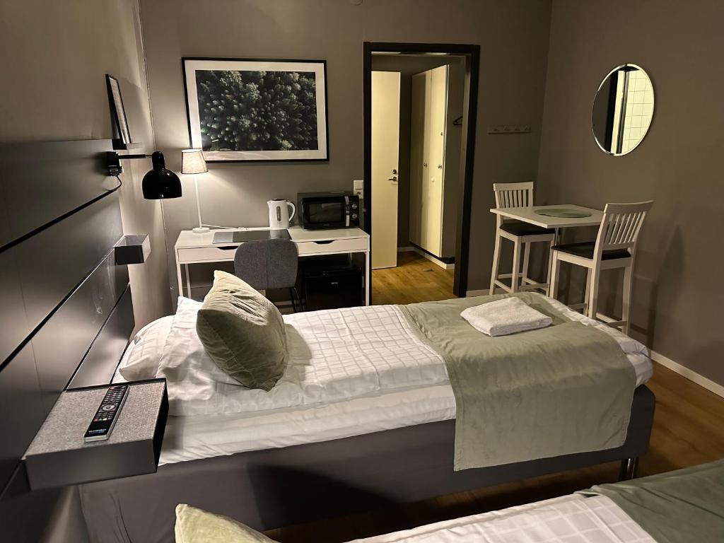 谢莱夫特奥Hotel B&B Gränden的一间带一张床和一张书桌的卧室和一间厨房