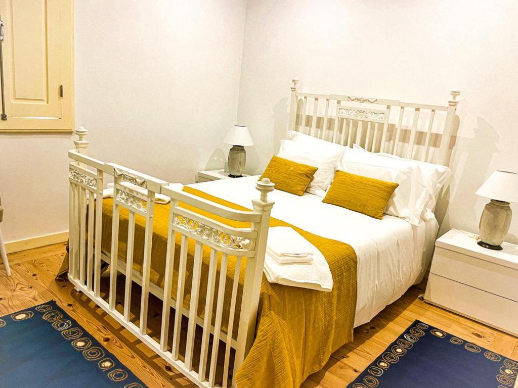 雷森迪Quintinha de Pinouco的卧室内的白色床和黄色枕头