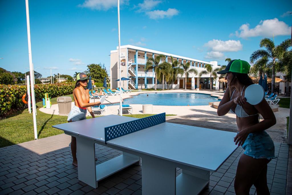 阿瓜迪亚Punta Borinquen Resort的几个人站在乒乓球桌旁