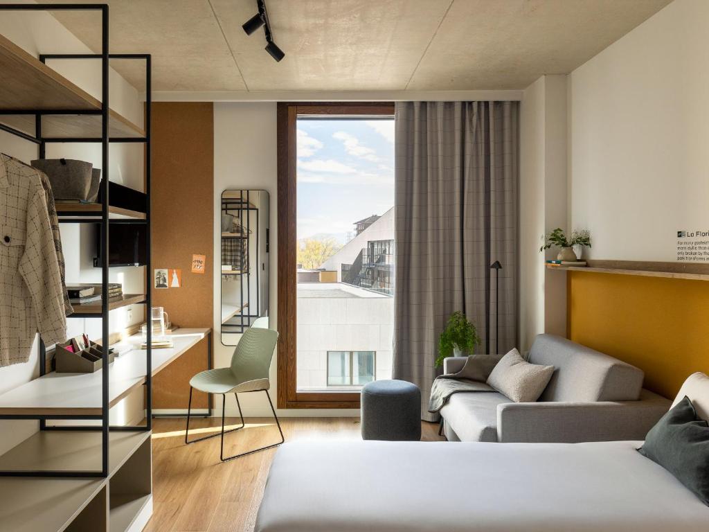 维多利亚-加斯特伊兹Kora Green City - Aparthotel Passivhaus的一间卧室设有一张床和一间客厅。
