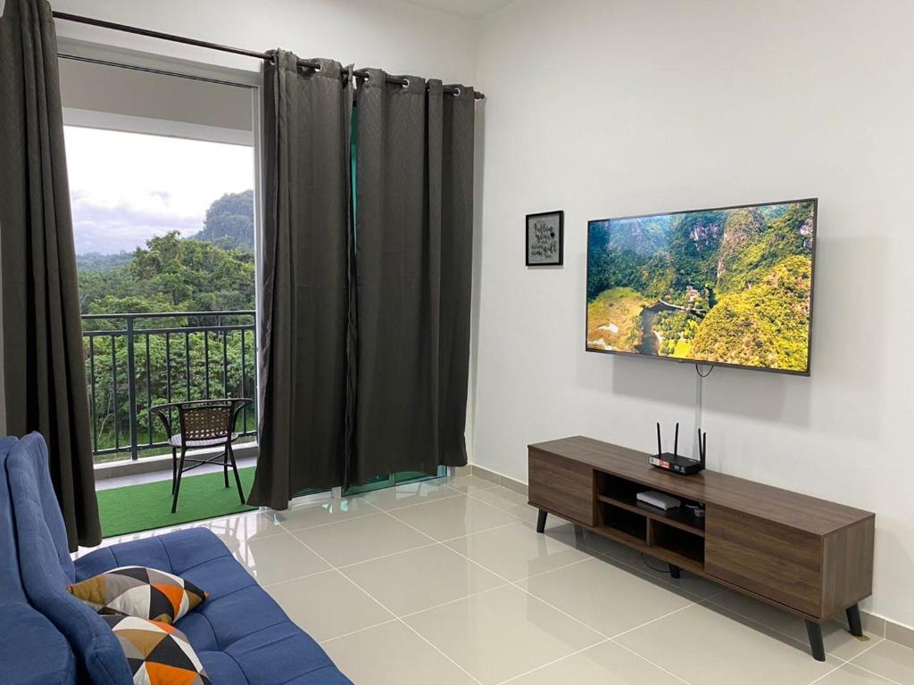 山打根Homestay Sandakan CLL的客厅设有蓝色的沙发和大窗户