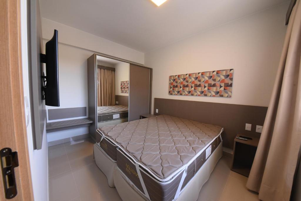 热河市Park Veredas Resort的一间卧室配有一张床和一面大镜子