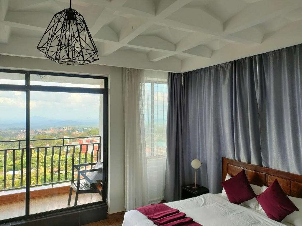 MeruTHE HOTEL EZRI的一间卧室设有一张床和一个大窗户