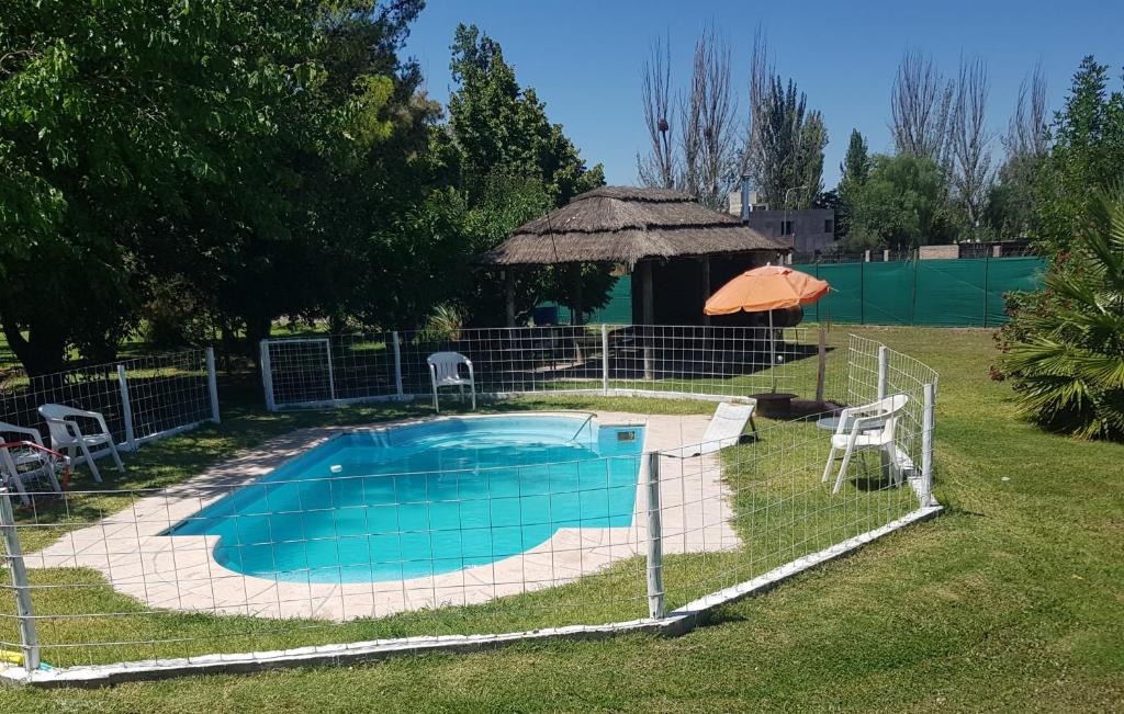 门多萨Posada y Cabañas "Finca El Rincón de Lunlunta"的一个带凉亭的庭院内的游泳池