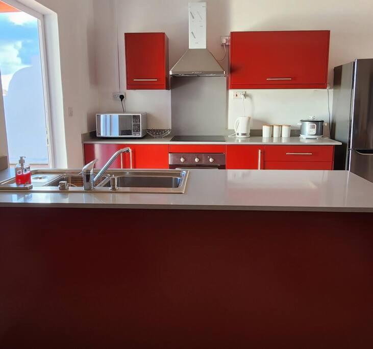 佩雷贝勒Peaceful holidays in Pereybere的厨房配有红色橱柜和不锈钢用具