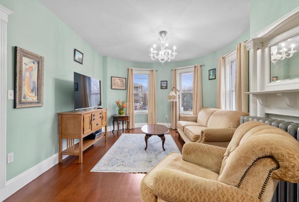 波士顿Bright & Spacious 2Br apartment, mins from Downtown Boston, parking的客厅设有两张沙发和一个壁炉