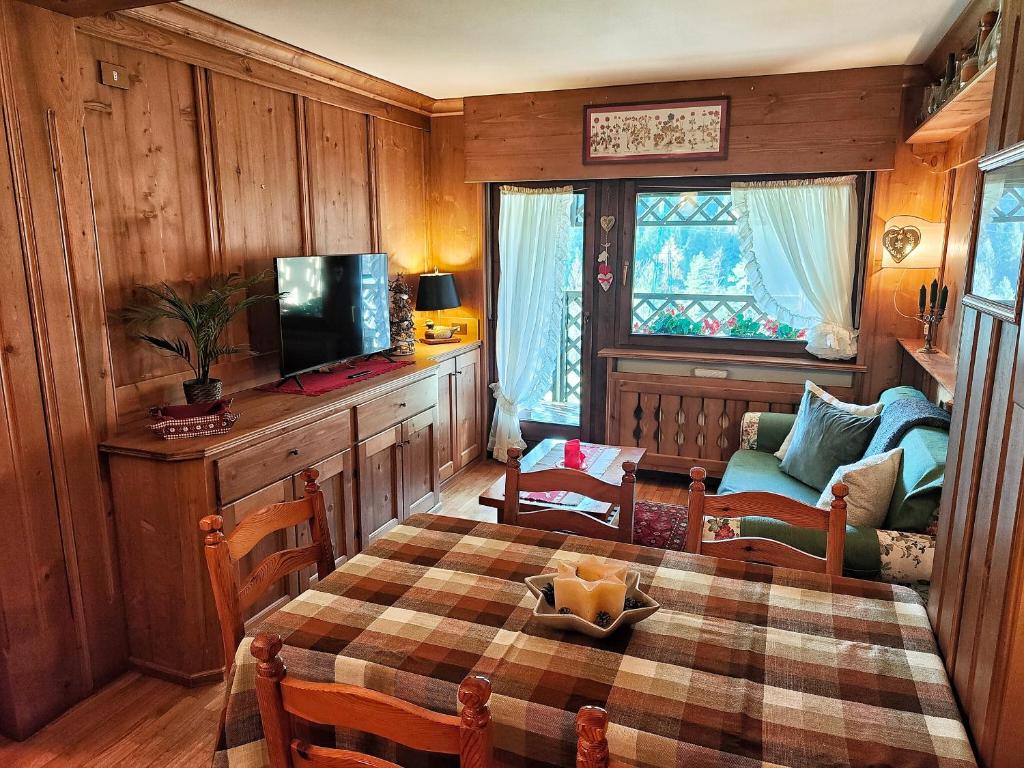 圣维托-迪卡多雷Hometoday - Appartamento nel cuore di San Vito di Cadore的客厅配有桌子、电视和沙发。