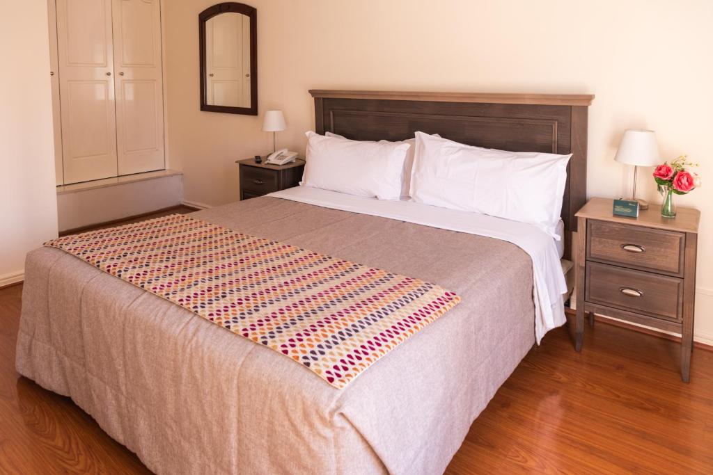 圣地亚哥MR Apart Providencia (ex Apart Neruda)的一间卧室设有一张大床和两个床头柜