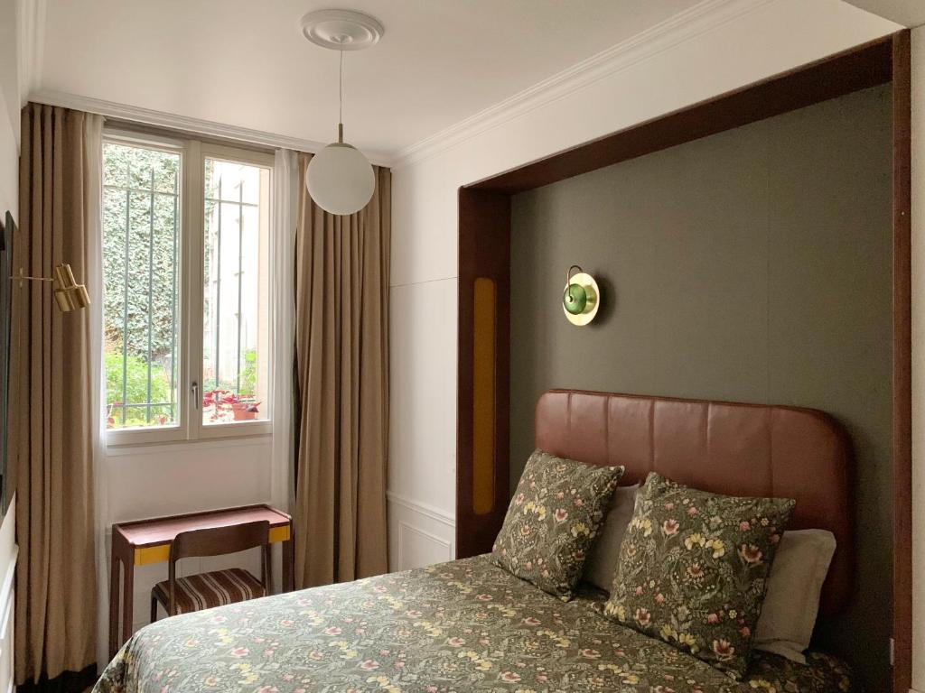 巴黎Chambre d’hôtes - Marais的一间卧室设有一张大床和一个窗户。