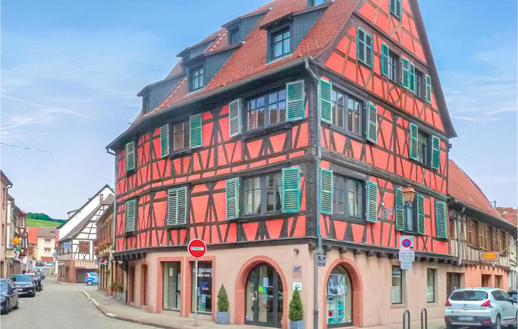 莫尔塞姆Awesome Apartment In Molsheim With 1 Bedrooms And Wifi的一座高大的建筑,设有红色和绿色的窗户