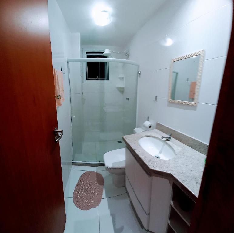 瓜拉派瑞Apartamento temporada com garagem, Wi-Fi, Netflix的浴室配有卫生间、盥洗盆和淋浴。