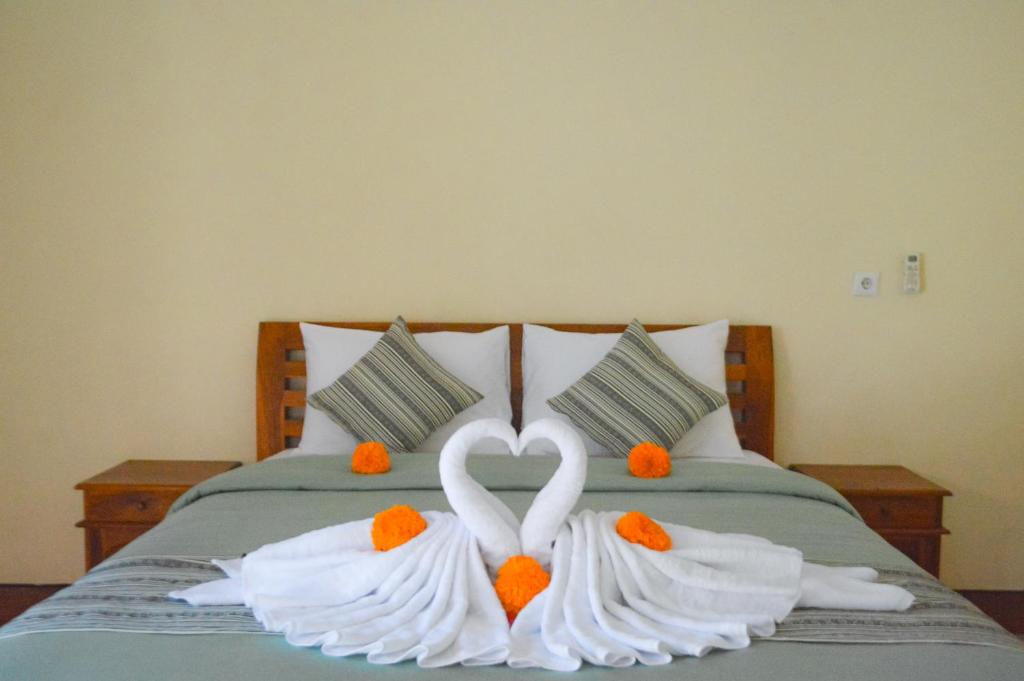 珀尼达岛Maja House Penida的两个白天鹅在床上心跳