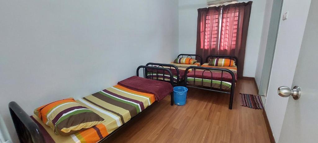 Bandar Puncak AlamHud Hud Homestay的带窗户的客房内的两张双层床