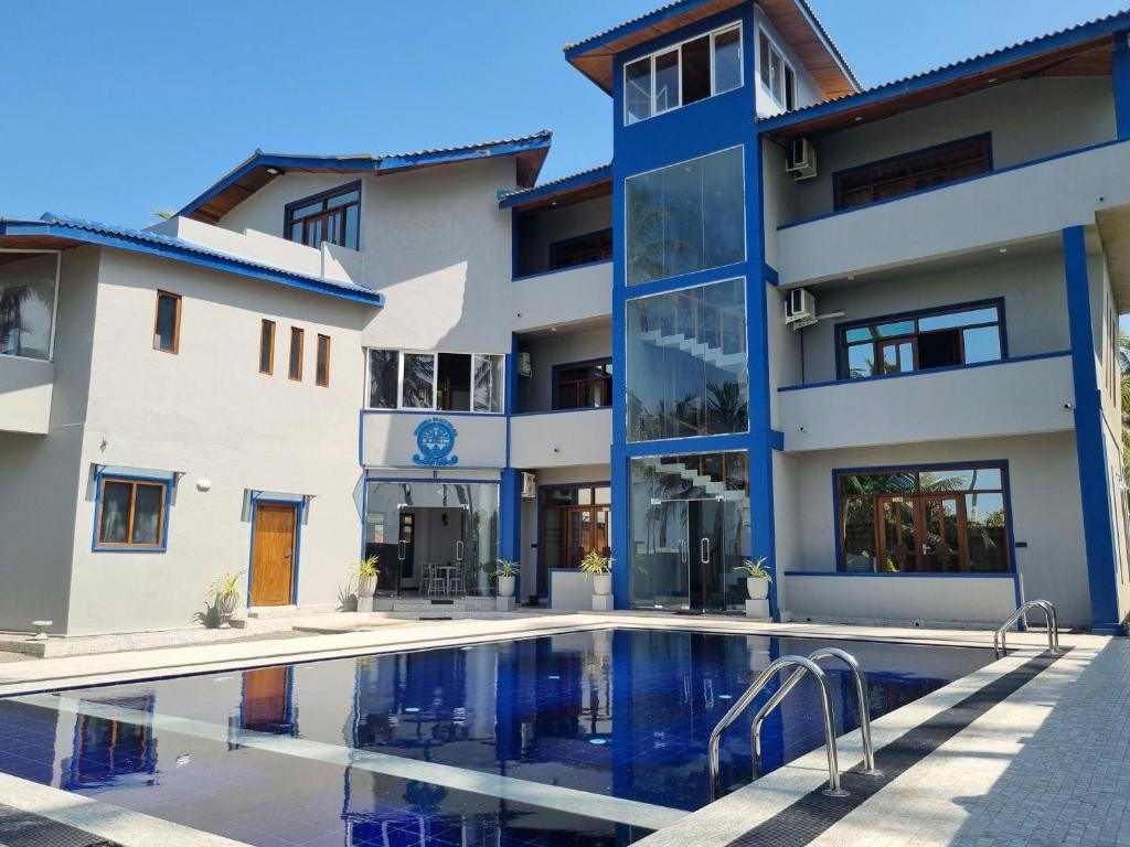 瓦都瓦Dhammika Beach Palace的公寓大楼前方设有游泳池