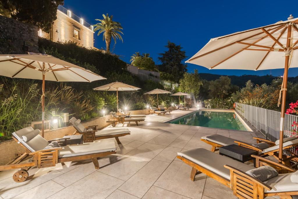 蒙蒂尼奥索Relais Montepepe Winery & Spa的毗邻度假酒店的带椅子和遮阳伞的游泳池