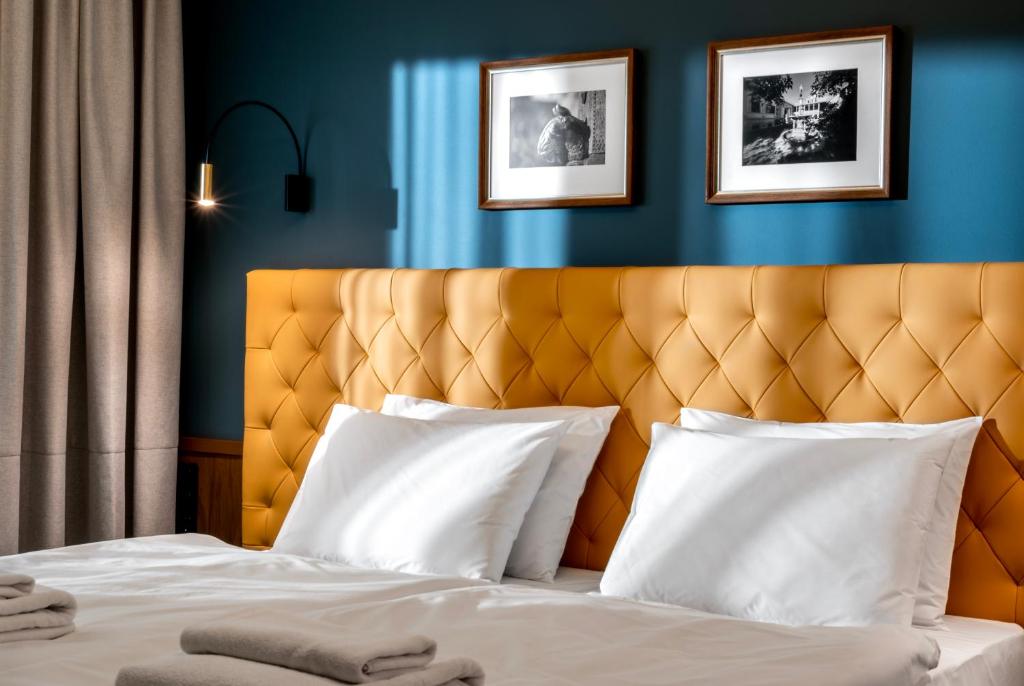 佩奇Palatinus Boutique Hotel的一间卧室配有一张黄色床头板的床
