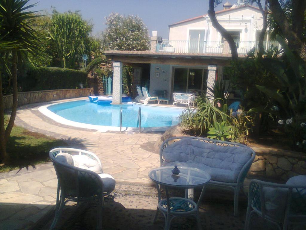 巴里萨尔多Villa Lanthana, 2 storeys, detached的房屋前设有桌椅的游泳池