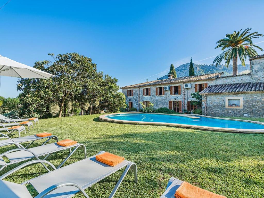波连斯萨Villa Can Fanals by SunVillas Mallorca的房屋前的带椅子的院子和游泳池