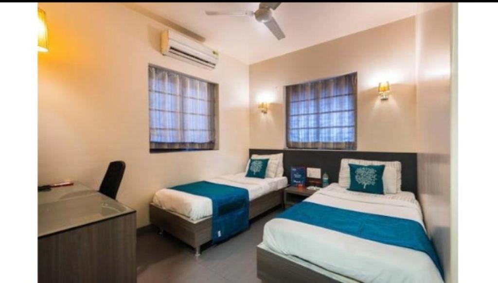 孟买Apollo Guest House的一间卧室配有两张床、一张桌子和一个水槽