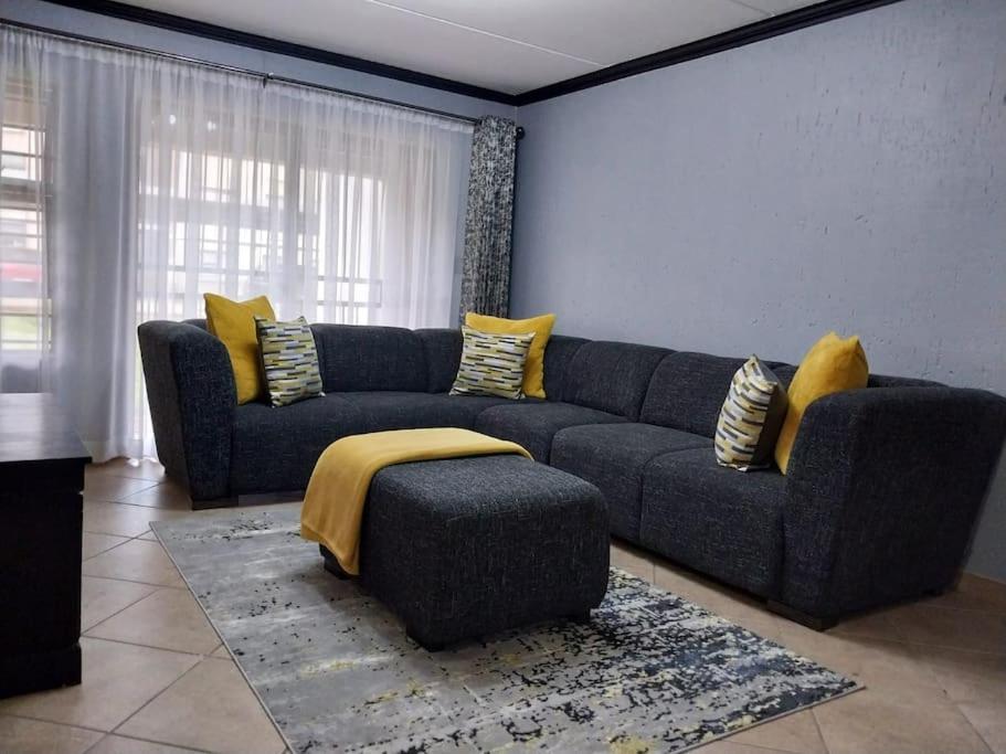 博克斯堡Maneli 69的客厅配有蓝色的沙发和黄色的枕头。