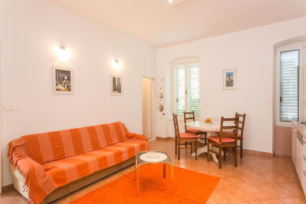 杜布罗夫尼克Apartment Tranquilo的客厅配有橙色沙发和桌子