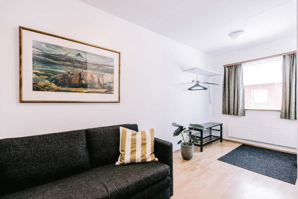 米湖埃尔达公寓的客厅配有黑色沙发和墙上的绘画
