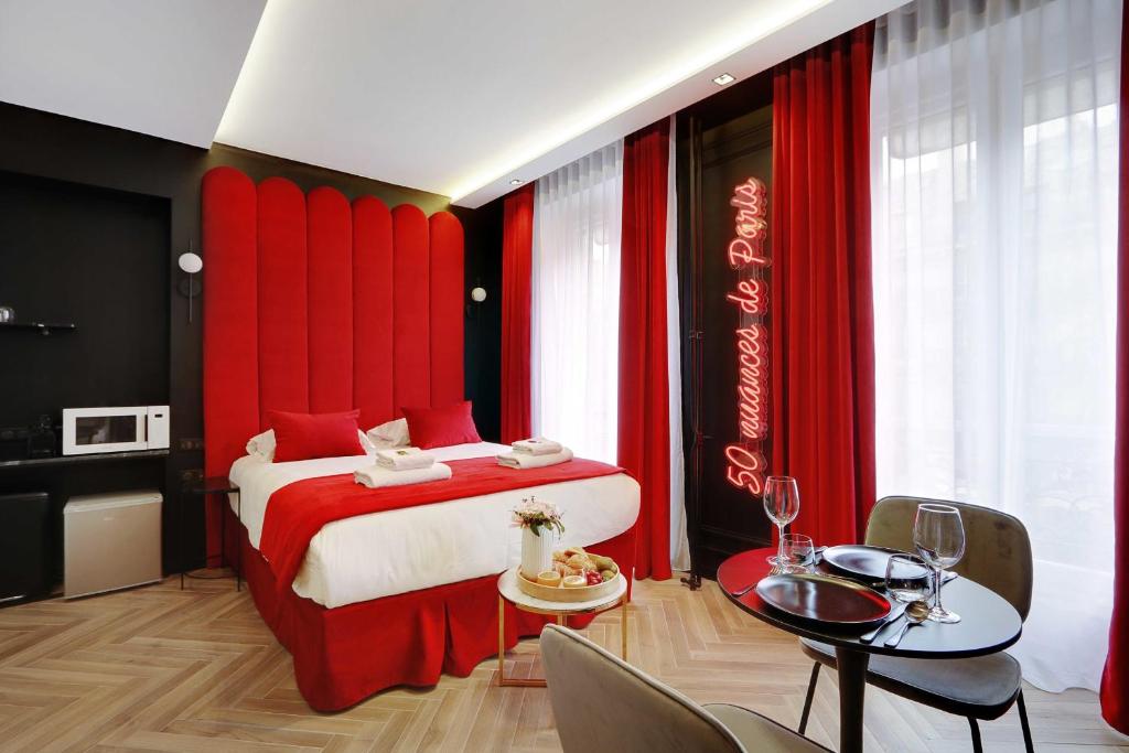 巴黎Couples Getaway Unit with Jacuzzi - City Center的一间卧室配有一张红色的床和桌椅