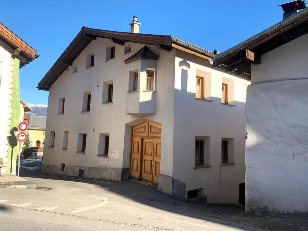 米施泰尔Privatzimmer Fasser in Müstair- Zentrale Lage的一座白色的大建筑,设有木门