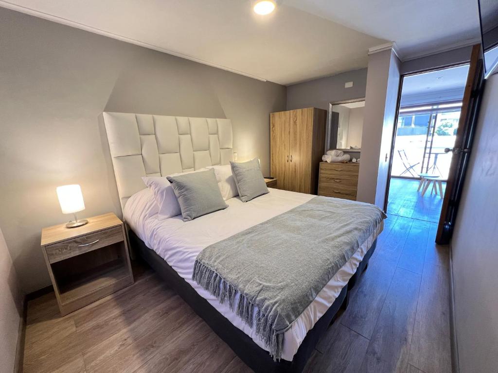 维纳德马Spazios Apart Hotel Reñaca的一间卧室配有一张大床和一张带台灯的桌子