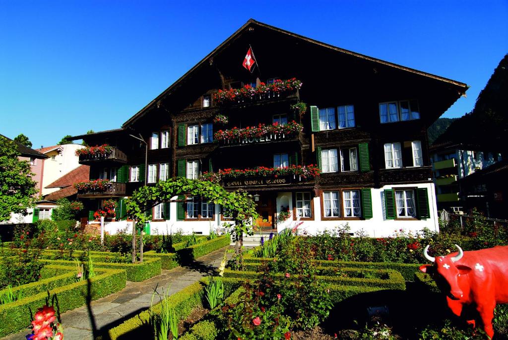 因特拉肯瑞士小屋酒店的前面有牛的建筑
