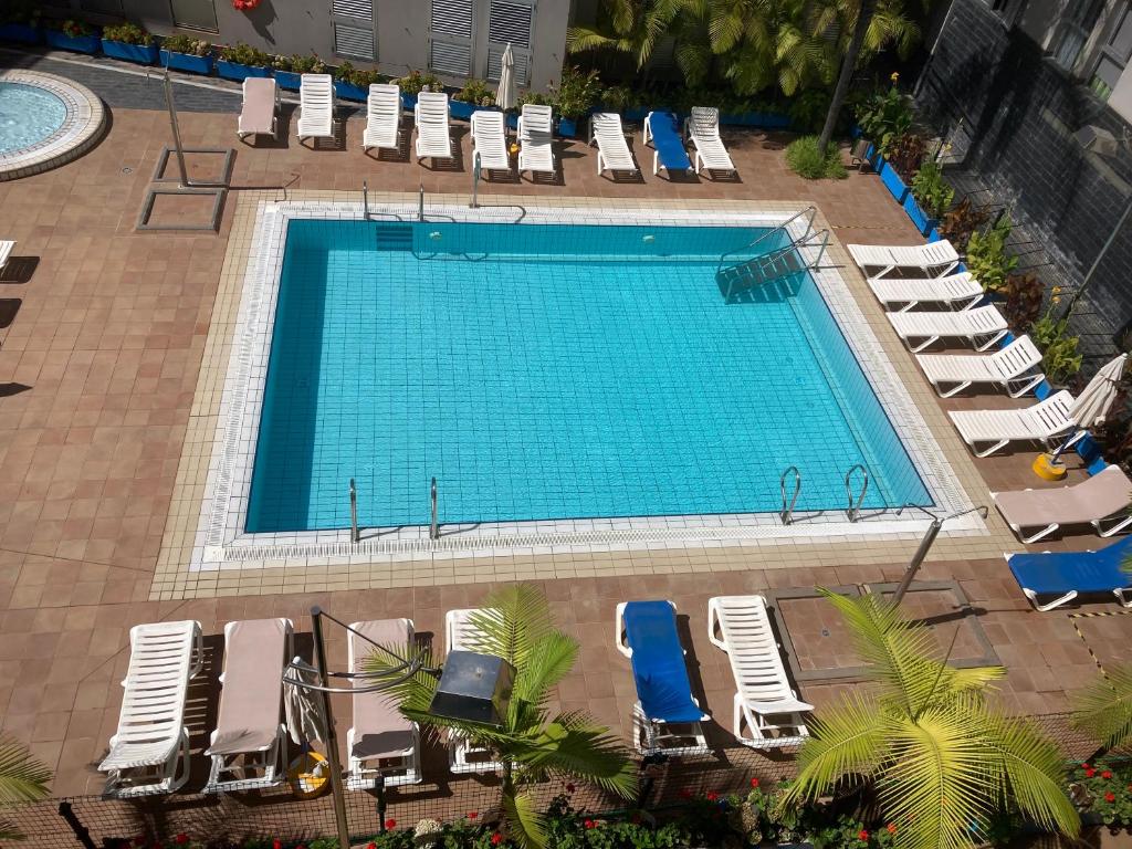 加尔达尔MARTSARAs PISCINA SARDINA的享有带躺椅和椅子的游泳池的顶部景致