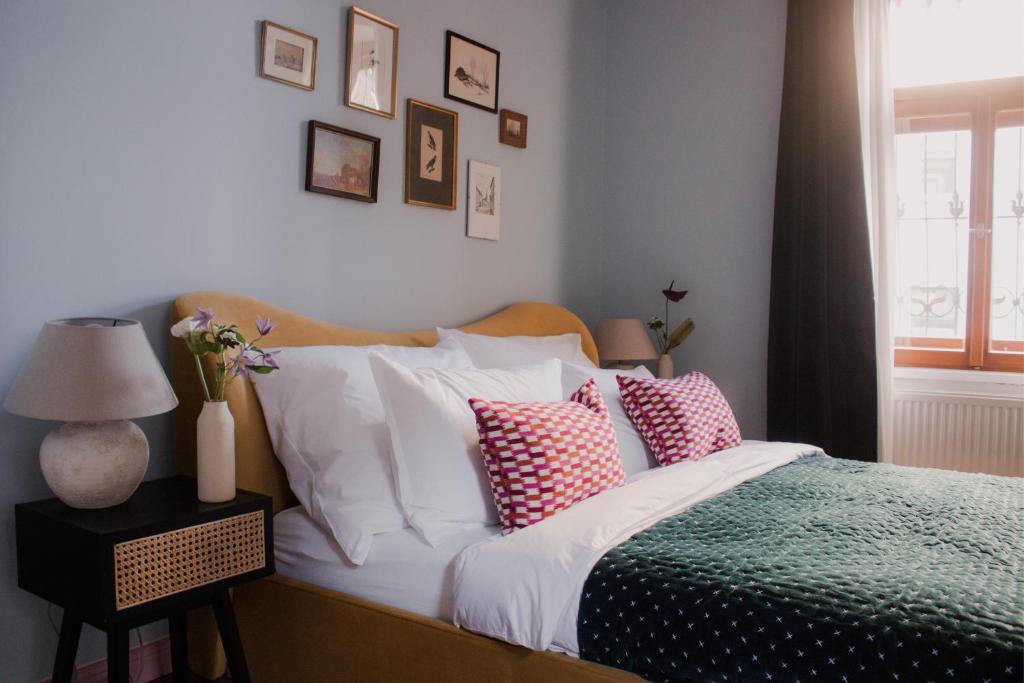 维也纳Oak House Vienna的一间卧室配有带白色和粉红色枕头的床